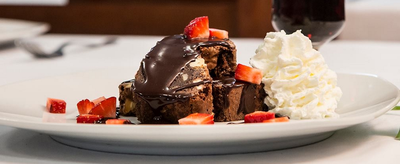 Brownie con sirope de chocolate, fresas y nata